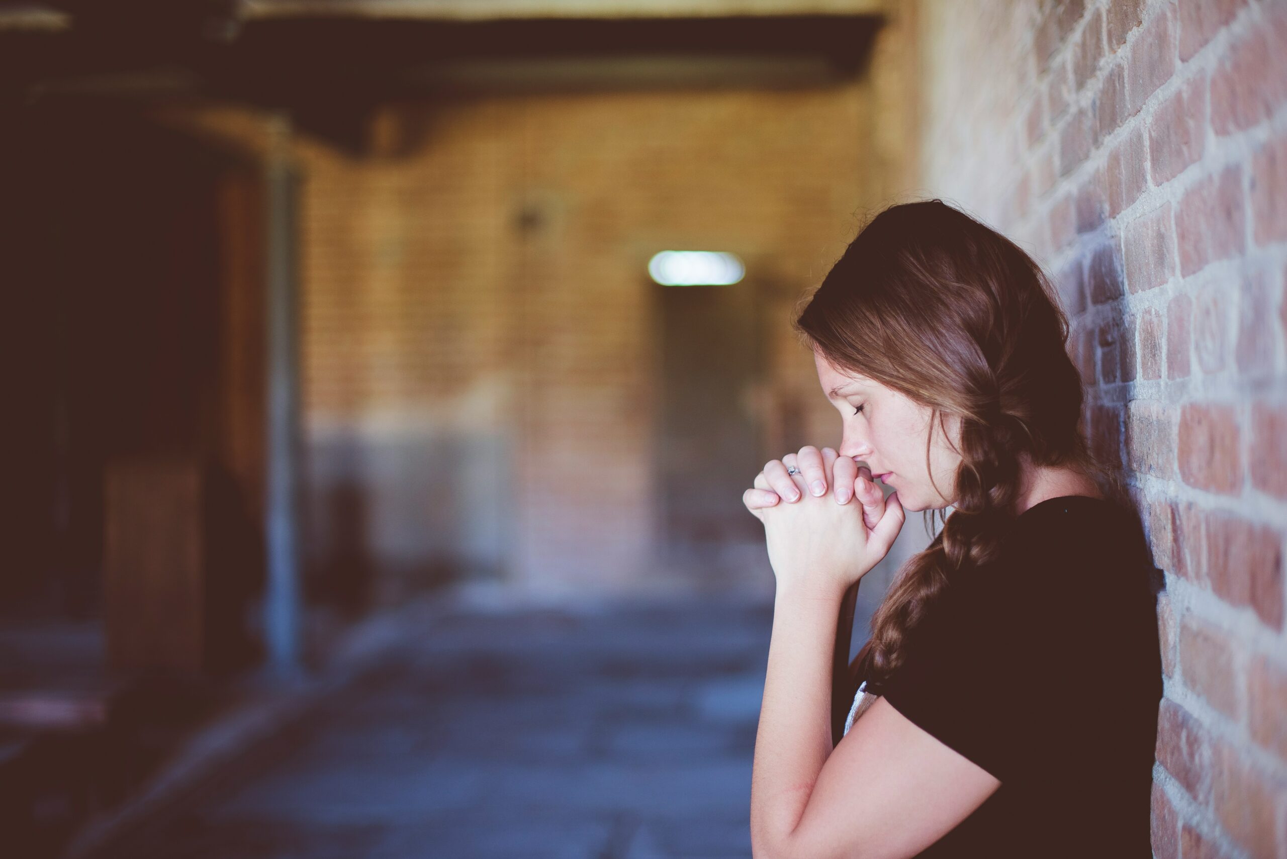woman praying in hallway